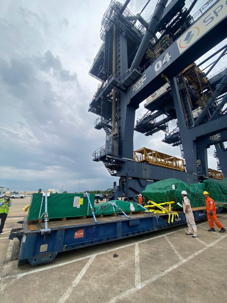 AlphaTrans team supervising the transport of a 125-ton WINTEC injection molding machine at Hiep Phuoc Port, Vietnam
