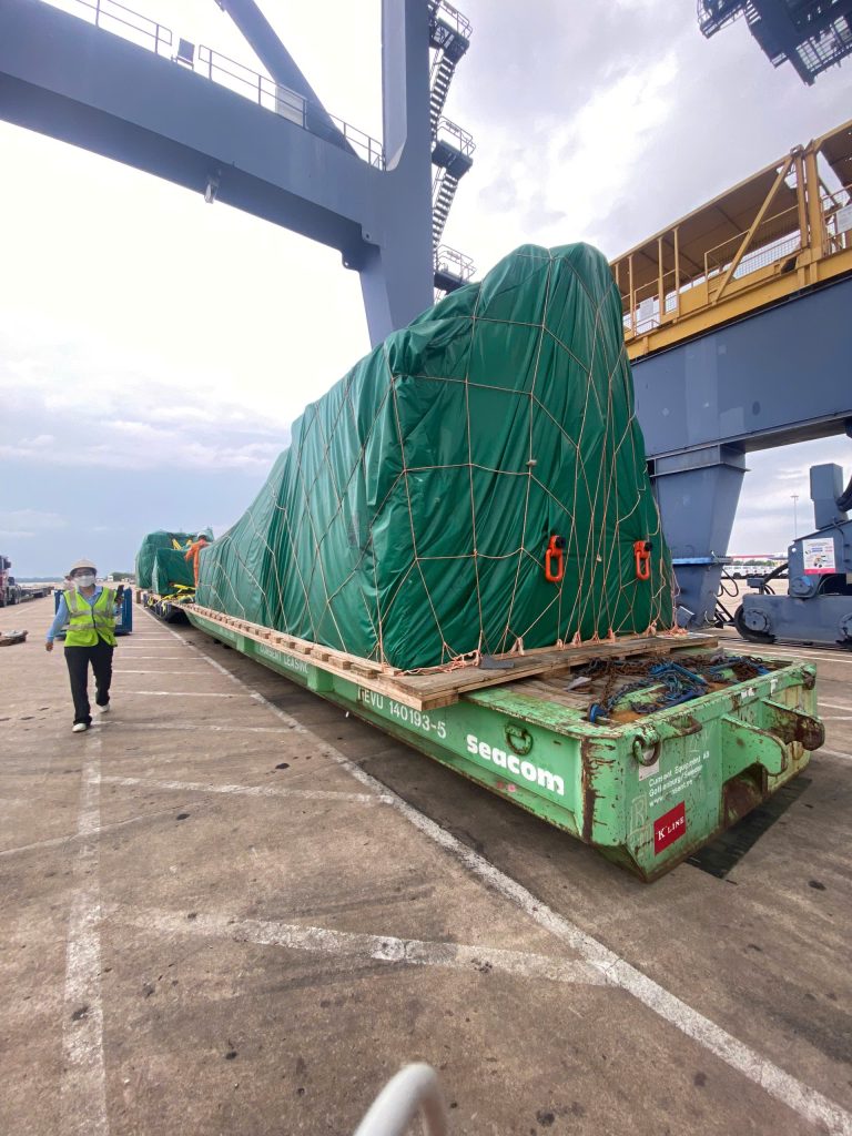 AlphaTrans team supervising the transport of a 125-ton WINTEC injection molding machine at Hiep Phuoc Port, Vietnam