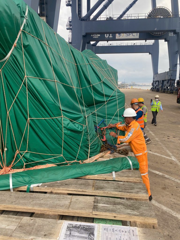AlphaTrans team supervising the transport of a 125-ton WINTEC injection molding machine at Hiep Phuoc Port, Vietnam