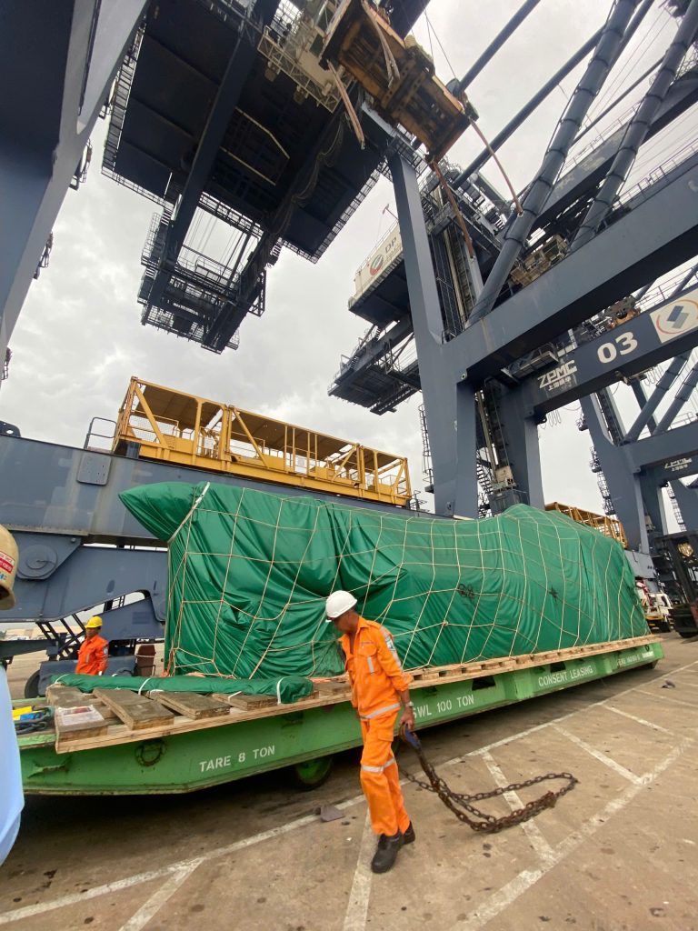 AlphaTrans team supervising the transport of a 125-ton WINTEC injection molding machine at Hiep Phuoc Port, Vietnam